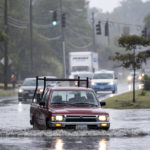 
              Vehicles make their way through floodwaters caused in part to the remnants of Hurricane Ian in the Larchmont neighborhood of Norfolk, Va.,on Monday, Oct. 3, 2022.  (Billy Schuerman/The Virginian-Pilot via AP)
            