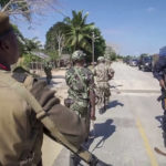 
              FILE - In this image made from video, a Rwandan policeman, right, and Mozambican military, left, patrol near the Amarula Palma hotel in Palma, Cabo Delgado province, Mozambique Sunday, Aug. 15, 2021. Fleeing beheadings, shootings, rapes and kidnappings, nearly 1 million people are displaced by the Islamic extremist insurgency in northern Mozambique. (AP Photo/Marc Hoogsteyns, File)
            