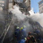 
              Firefighters work after a drone fired on buildings in Kyiv, Ukraine, Monday, Oct. 17, 2022. Waves of explosive-laden suicide drones struck Ukraine's capital as families were preparing to start their week early Monday, the blasts echoing across Kyiv, setting buildings ablaze and sending people scurrying to shelters. (AP Photo/Roman Hrytsyna)
            