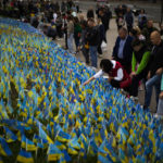 
              People place Ukrainian flags in memory of civilians killed during the war at the Independence square in central Kyiv, Ukraine, Saturday, Oct. 1, 2022. (AP Photo/Francisco Seco)
            