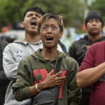 
              Men are overcome by emotion as they offer prayers for the victims of Saturday's soccer stampede outside the Kanjuruhan Stadium in Malang, East Java, Indonesia, Wednesday, Oct. 5, 2022. Indonesia's President Joko Widodo said on Wednesday that locked gates had contributed to the crush at the soccer stadium that left a number of people dead and hundreds others injured when police fired tear gas and set off a panicked run for the exits. (AP Photo/Dicky Bisinglasi)
            
