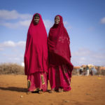 
              Abdiyo Barre Ali, right and Abdiyo Ali Abdi recite poetry at a camp for displaced people on the outskirts of Dollow, Somalia, on Wednesday, Sept. 21, 2022.  Somalia is in the midst of the worst drought anyone there can remember. A rare famine declaration could be made within weeks. Climate change and fallout from the war in Ukraine are in part to blame. (AP Photo/Jerome Delay)
            