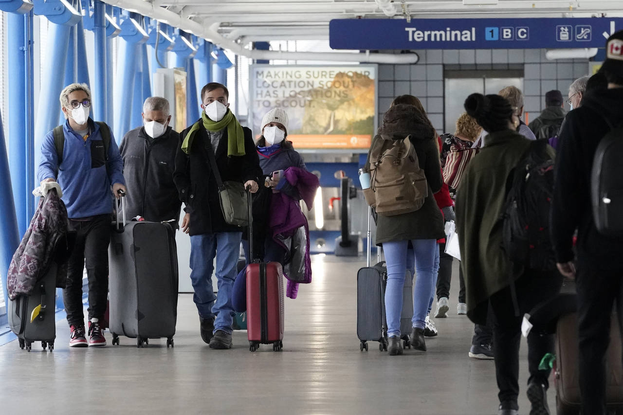 FILE - Travelers walk through Terminal 1 at O'Hare International Airport in Chicago, on Dec. 30, 20...