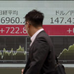 
              A person walk in front of an electronic stock board showing Japan's Nikkei index and U.S. dollar/Japanese yen exchange rate at a securities firm Friday, Oct. 14, 2022, in Tokyo. Asian stock markets surged Friday after Wall Street rebounded from a slump caused by worse-than-forecast inflation numbers. (AP Photo/Eugene Hoshiko)
            
