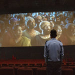 
              A security guard watches the trailer on a screen as engineers check for sound and picture quality ahead of the inauguration of 'INOX' multiplex in Srinagar, Indian controlled Kashmir, Monday, Sept. 19, 2022.  The multi-screen cinema hall has opened in the main city of Indian-controlled Kashmir for public for the first time in 14 years. The 520-seat hall with three screens opened on Saturday, Oct. 1, amid elaborate security but only about a dozen viewers lined up for the first morning show. (AP Photo/Dar Yasin)
            