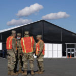 
              Members of the New York National Guard stand outside the Randall's Island Humanitarian Emergency Response and Relief Center, Wednesday, Oct. 19, 2022, New York City's latest temporary shelter for an influx of international migrants being bused into the city by southern border states. (AP Photo/Julia Nikhinson)
            