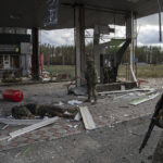 
              Ukrainian servicemen find a body of their comrade on the destroyed petrol station in the recently recaptured town of Lyman, Ukraine, Monday, Oct. 3, 2022. (AP Photo/Evgeniy Maloletka)
            