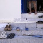 
              An injured Afghan stands on the stairs of an old school used as a temporary shelter on the island of Kythira, southern Greece, Friday, Oct. 7, 2022. Strong winds were hampering rescue efforts at two Greek islands Friday for at least 10 migrants believed to be missing after shipwrecks left more than 20 people dead, officials said. (AP Photo/Thanassis Stavrakis)
            