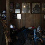 
              With framed family photos hanging on the wall, 80-year-old Clifford Weyiouanna, a respected village elder and former reindeer herder, rests on a sofa in his home in Shishmaref, Alaska, Saturday, Oct. 1, 2022. (AP Photo/Jae C. Hong)
            