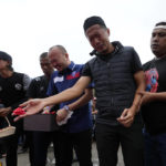 
              Soccer club Arema FC players and officials pray for the victims of Saturday's deadly crush outside Kanjuruhan Stadium in Malang, Indonesia, Monday, Oct. 3, 2022. Police firing tear gas at Saturday night's match between host Arema FC of East Java's Malang city and Persebaya Surabaya in an attempt to stop violence triggered a disastrous crush of fans making a panicked, chaotic run for the exits, leaving a large number of people dead, most of them trampled upon or suffocated. (AP Photo/Achmad Ibrahim)
            