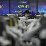 
              A currency trader walks by screens showing the Korean Securities Dealers Automated Quotations (KOSDAQ), center, and the foreign exchange rates at a foreign exchange dealing room in Seoul, South Korea, Friday, Oct. 7, 2022. Asian shares followed Wall Street lower Friday ahead of U.S. jobs data investors hope will persuade the Federal Reserve to ease off plans for more interest rate hikes. (AP Photo/Lee Jin-man)
            
