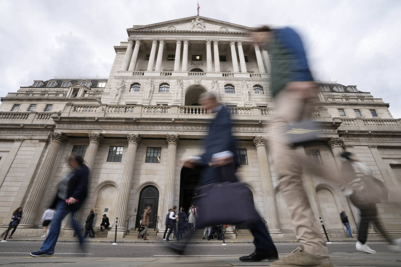 FILE - People pass the Bank of England in London, Wednesday, Sept. 28, 2022. On Tuesday, Oct. 11, 2...