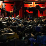 
              FILE - Migrants sleep on the deck of the Spanish NGO Open Arms lifeguard ship after they were rescued from open waters during an operation in the international waters zone, on the Mediterranean sea, Sept. 20, 2022. The back-to-back shipwrecks of migrant boats off Greece that left at least 22 people dead this week has once again put the spotlight on the dangers of the Mediterranean migration route to Europe. (AP Photo/Petros Karadjias, file)
            