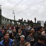 
              People gather to demonstrate in solidarity with students and teachers demanding higher wages and better working conditions, at Liberty Bridge, in Budapest, Hungary, Sunday, Oct. 23, 2022, on the national holiday of the 66th anniversary of the Hungarian anti-communist uprising of 1956. (AP Photo/Anna Szilagyi)
            