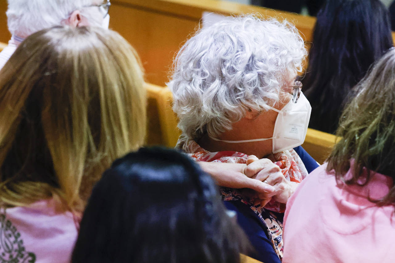 Karen Harris, right, daughter of victim Miriam Nelson, reacts as she embraces her husband Cliff Har...