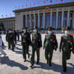 
              FILE - Military attendees leave after the opening ceremony of the 20th National Congress of China's ruling Communist Party at the Great Hall of the People in Beijing on Oct. 16, 2022. In a speech that used the word security 26 times, Chinese leader Xi Jinping said Beijing will "work faster" to modernize the party's military wing, the People's Liberation Army, and "enhance the military's strategic capabilities." (AP Photo/Mark Schiefelbein, File)
            