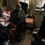 
              A volunteer urges a local elderly woman to leave her house located in a combat zone in the village of Zarechne, Donetsk region, Monday, Oct. 17, 2022. (AP Photo/LIBKOS)
            