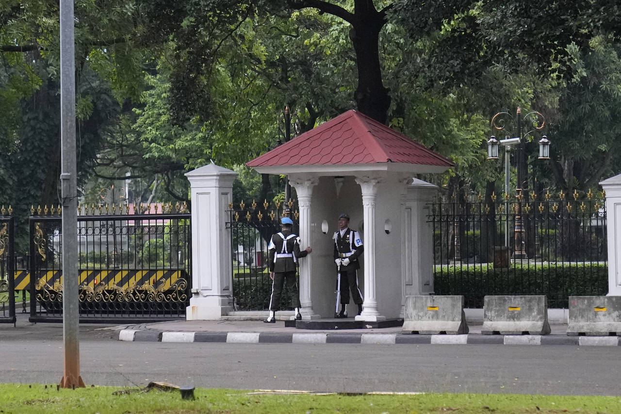 Members of The Presidential Guards man a post outside Merdeka Palace in Jakarta, Indonesia, Tuesday...