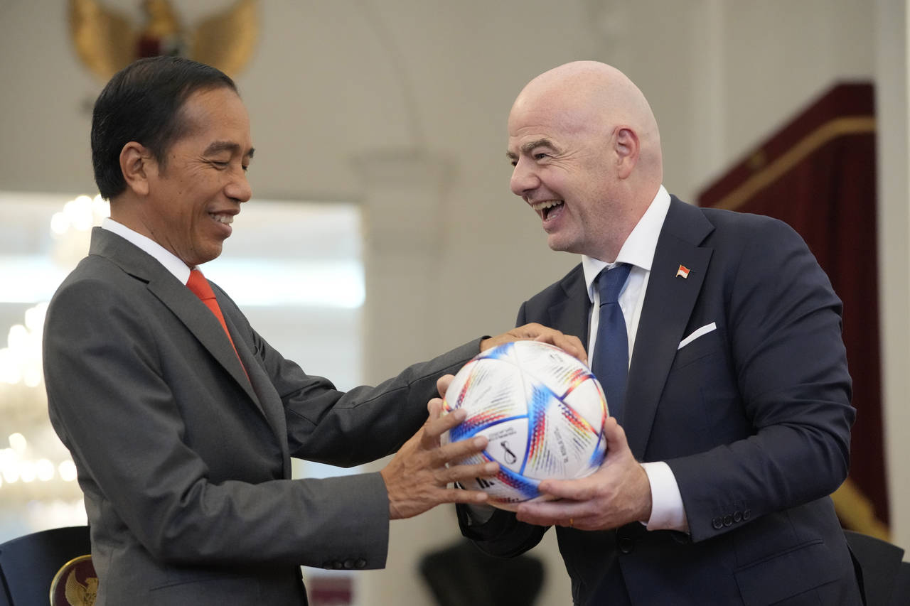 Indonesian President Joko Widodo, left, receives a gift of a ball from FIFA President Gianni Infant...