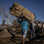
              Workers recover tobacco from a drying barn that was destroyed one week ago by Hurricane Ian in La Coloma, Pinar del Rio province, Cuba, Wednesday, Oct. 5, 2022. (AP Photo/Ramon Espinosa)
            