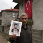 
              Recep Ayvaz, 62, shows a picture of his son, Selcuk Ayvas, 33, one of the miners killed in a coal mine explosion, in front of his house in Amasra, in the Black Sea coastal province of Bartin, Turkey, Sunday, Oct. 16, 2022. (AP Photo/Khalil Hamra)
            