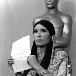 
              FILE - Sacheen Littlefeather, a Native American activist, tells the audience at the Academy Awards ceremony in Los Angeles, March 27, 1973, that Marlon Brando was declining to accept his Oscar as best actor for his role in "The Godfather." Sacheen Littlefeather died Sunday, Oct. 2, 2022, at her home in Marin County, Calif. She was 75. (AP Photo/File)
            