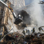 
              Firefighters work after a drone attack on buildings in Kyiv, Ukraine, Monday, Oct. 17, 2022. Waves of explosive-laden suicide drones struck Ukraine's capital as families were preparing to start their week early Monday, the blasts echoing across Kyiv, setting buildings ablaze and sending people scurrying to shelters. (AP Photo/Roman Hrytsyna)
            