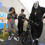 
              Actress Sally Tanner, left, Shelia Williams, a retired register nurse, middle, dance with warehouse worker, Richard Garcia, dressed as "The Nun," as they line up to buy lottery tickets for the Powerball lottery at the Blue Bird Liquor store in Hawthorne, Calif., Monday, Oct. 31, 2022. The jackpot for Monday night's drawing soared after no one matched all six numbers in Saturday night's drawing. It's the fifth-largest lottery jackpot in U.S. history. (AP Photo/Damian Dovarganes)
            