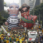 
              FILE - Demonstrators parade large inflatable dolls depicting Brazil's former President Luiz Inacio Lula da Silva in prison garb and current President Dilma Rousseff dressed as a thief, with a presidential sash that reads "Impeachment," in Sao Paulo, Brazil, March 13, 2016. (AP Photo/Andre Penner, File)
            