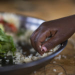 
              A girl eats at a school in Dollow, Somalia, on Monday, Sept. 19, 2022. At midday, dozens of hungry children from the camps try to slip into a local primary school where the World Food Program offers a rare lunch program for students. (AP Photo/Jerome Delay)
            