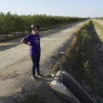 
              Elaine Moore stands next to a dry irrigation canal and almond orchard near her property, where two wells have gone dry this summer in Chowchilla, Calif., Sept. 14, 2022. Amid a megadrought plaguing the American West, more rural communities are losing access to groundwater as heavy pumping depletes underground aquifers that aren’t being replenished by rain and snow. (AP Photo/Terry Chea)
            