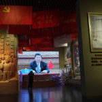 
              Chinese President Xi Jinping is seen on a screen near a photo showing him wearing a mask at an exhibition highlight China's fight against COVID-19 at the Museum of the Community Party of China in Beijing on Oct. 12, 2022. Xi is facing a challenge to his government's harsh "zero-COVID" policies, which have taken an economic and human toll. Small groups of residents staged protests during an extended lockdown in Shanghai earlier this year. In a rare political protest, someone hung banners from an elevated highway in Beijing this week attacking the policy and Xi himself. (AP Photo/Ng Han Guan)
            