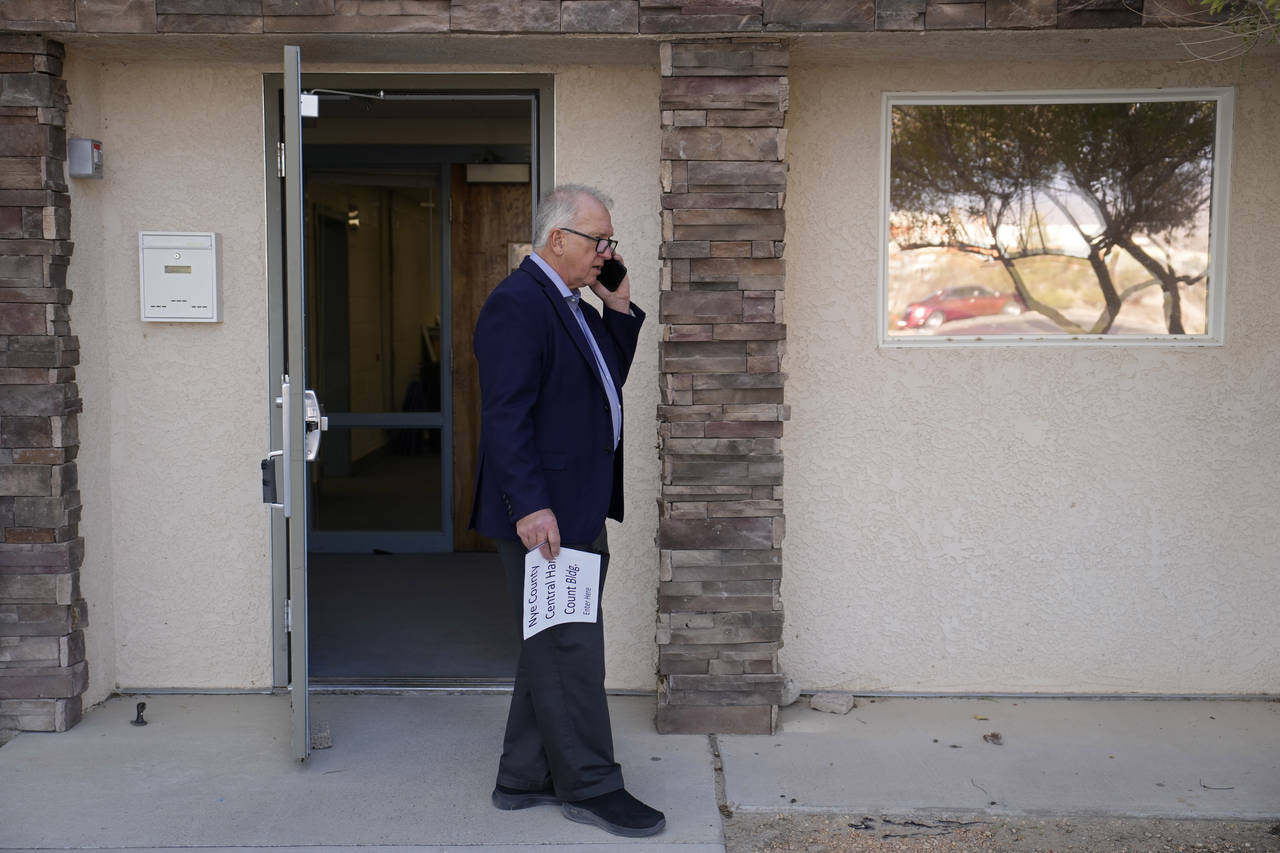 Interim Nye County Clerk Mark Kampf speaks on the phone outside of a building where early votes are...