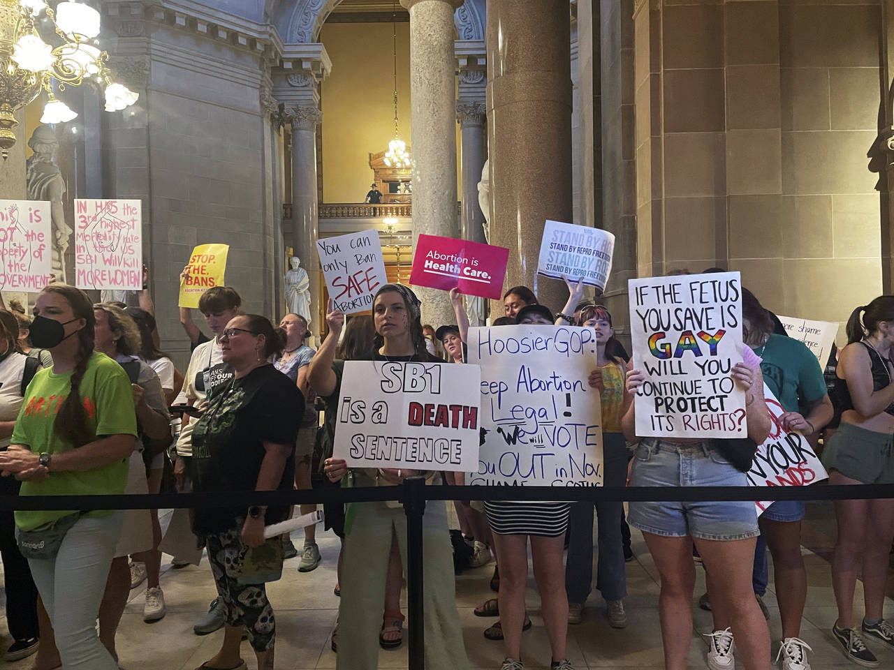 FILE - Abortion-rights protesters fill Indiana Statehouse corridors and cheer outside legislative c...