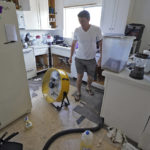 
              Jordan Cromer cleans up water from his home, Tuesday, Oct. 4, 2022, in North Port, Fla. Residents along Florida's west coast are cleaning up damage after Hurricane Ian make landfall last week. (AP Photo/Chris O'Meara)
            
