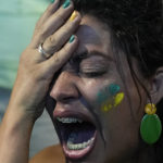 
              A supporter of Brazilian President Jair Bolsonaro reacts to results after polls closed in a presidential run-off election, in Rio de Janeiro, Brazil, Sunday, Oct. 30, 2022. Brazil's electoral authority announced that former President Luiz Inacio Lula da Silva defeated Bolsonaro to become the country's next president. (AP Photo/Silvia Izquierdo)
            