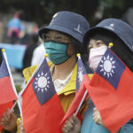 
              People take photos with Taiwan national flags during National Day celebrations in front of the Presidential Building in Taipei, Taiwan, Monday, Oct. 10, 2022. (AP Photo/Chiang Ying-ying)
            