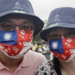 
              People wear masks patterned with Taiwan national flags during National Day celebrations in front of the Presidential Building in Taipei, Taiwan, Monday, Oct. 10, 2022. (AP Photo/Chiang Ying-ying)
            