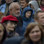 
              People queue to receive a daily ration of bread in a school in Mykolaiv, Tuesday, Oct. 25, 2022. Mykolaiv residents pick up bread from the only food distribution point in Varvarivka, a Mykolaiv district where thousands of people live. One person is allowed to receive free bread just once in three days. (AP Photo/Emilio Morenatti)
            