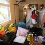 
              Contractors Miguel Ortiz, left, and Mitchell Brown, take down a waterlogged heavy bag used for boxing, so that apartment resident Janelle Thiel, right, can salvage the bracket used to hang it, after the apartment flooded to waist-height during the passage of Hurricane Ian, at the Riverwalk complex in Fort Myers, Fla., Wednesday, Oct. 5, 2022. (AP Photo/Rebecca Blackwell)
            