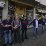 
              Demonstrators by the Italian Partisans association form a human chain to protect shops selling memorabilia of Fascist Dictator Benito Mussolini, during a march organized in Mussolini's birthplace Predappio Friday, Oct. 28, 2022, to mark the 78th anniversary of the liberation of the town from the nazi-fascist occupation by Italian Partisans and Polish allied troops, which coincides with the 100th anniversary of the march on Rome. (AP Photo/Luca Bruno)
            