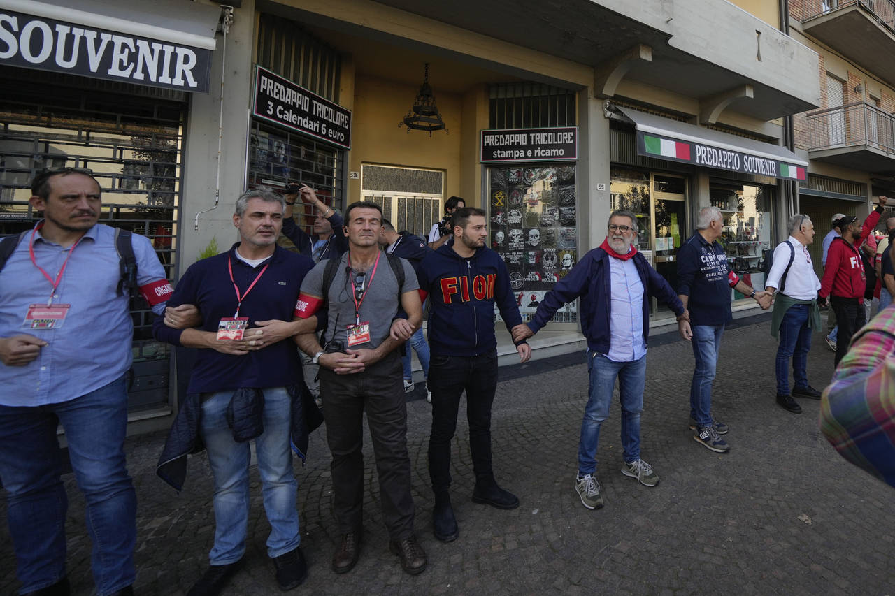Demonstrators by the Italian Partisans association form a human chain to protect shops selling memo...