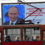 
              People look through the tram windows as they pass a big screen showing Russian President Vladimir Putin and reading: "Happy birthday to President Vladimir Putin from the Serb brethren!", in Belgrade, Serbia, Friday, Oct. 7, 2022. The posters are signed by a Pro-Russian right-wing group. Putin remains popular in Serbia despite the attack on Ukraine, and many in the Balkan country believe that the Russian president was provoked by the West into launching the invasion. (AP Photo/Darko Vojinovic)
            