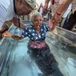 
              A woman is baptized during the ReAwaken America Tour at Cornerstone Church in Batavia, N.Y., Friday, Aug. 12, 2022. In the version of America laid out at the ReAwaken tour, Christianity is at the center of American life and institutions, it's under attack, and attendees need to fight to restore and protect the nation's Christian roots. It’s a message repeated over and over at ReAwaken — one that upends the constitutional ideal of a pluralist democracy. (AP Photo/Carolyn Kaster)
            