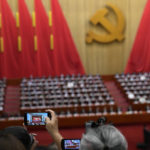 
              Attendees take photos during the closing ceremony of the 20th National Congress of China's ruling Communist Party at the Great Hall of the People in Beijing, Saturday, Oct. 22, 2022. (AP Photo/Ng Han Guan)
            