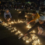 
              People light candles during a vigil at Kanjuruhan Stadium in Malang, East Java, Indonesia, Friday, Oct. 7, 2022. Indonesian police said they are bringing criminal charges against three officers and three civilians for their roles in the deaths of more than 100 people when police fired tear gas in the soccer stadium after a match on Saturday, setting off a panicked run for the exits in which many were crushed. (AP Photo/Dicky Bisinglasi)
            