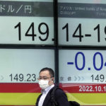 
              FILE - A person wearing a protective mask walks past an electronic stock board showing Japan's Yen/U.S. Dollar exchange rate at a securities firm in Tokyo on Oct. 19, 2022. Japan marked a trade deficit for the 14th month in a row, government data showed Thursday, Oct. 20, 2022 with exports and imports ballooning to record highs, as the declining value of the yen added to the soaring costs of imported energy, food and other goods. (AP Photo/Eugene Hoshiko, File)
            