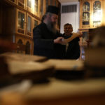 
              Father Theofilos, a Pantokrator monk reads a manuscript as Anastasios Nikopoulos, a jurist and scientific collaborator of the Free University of Berlin, looks on at the library of Pantokrator Monastery in the Mount Athos, northern Greece, on Thursday, Oct. 13, 2022. Deep inside a medieval fortified monastery in the Mount Athos monastic community, researchers are for the first time tapping a virtually unknown treasure: thousands of Ottoman-era manuscripts that include the oldest of their kind in the world. (AP Photo/Thanassis Stavrakis)
            
