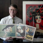 
              Dwight Cleveland, a major collector of movie posters and lobby cards, poses for a portrait with a three lobby card and movie poster Tuesday, Sept. 27, 2022, in Chicago. Many silent films from the early 1900s no longer exist. But they live on in movie theater lobby cards. More than 10,000 of the mostly 11-by-14-inch cards that promoted the cinematic romances, comedies and adventures of the era are being digitized for preservation and publication online, thanks to an agreement formed between a Chicago-based collector Cleveland and Dartmouth College. (AP Photo/Charles Rex Arbogast)
            