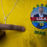 
              A man wearing a Brazil jersey with a sticker of former Brazilian President Luiz Inacio "Lula" da Silva, who is running for president, poses for a photo during general elections, in Acegua, Brazil, Sunday, Oct. 2, 2022. (AP Photo/Matilde Campodonico)
            